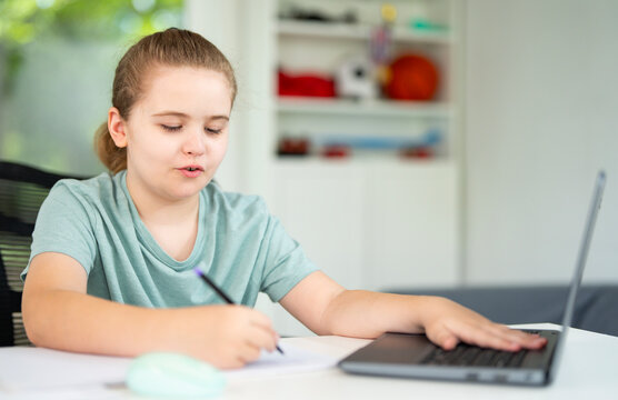 Back to school. Child with laptop at school classroom. Student sitting at desk during distance school class. Smart child study in virtual school.
