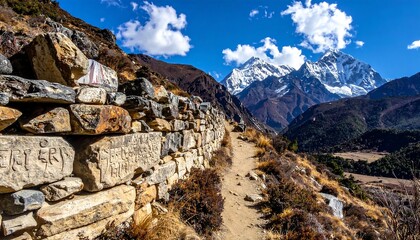 Mountain trail with stone wall and snowy peak