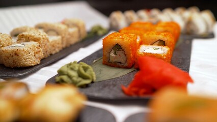 Sushi rolls served on restaurant black plates