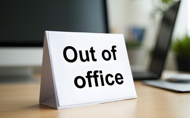 A clear 'Out of Office' sign displayed on a well-arranged desk suggesting absence. High quality