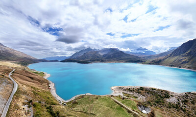 Mountain road winding along lake Lac du Mont Cenis, Savoie, Auvergne-Rhone-Alpes, France, Europe.