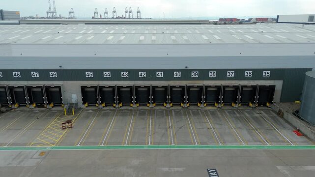 Aerial  close up drone view of industrial warehouse factory loading bay doors 
