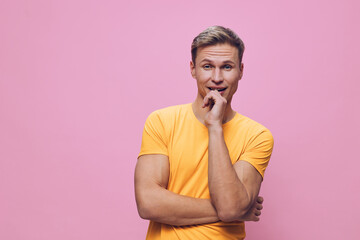 Fototapeta premium thoughtful man orange t-shirt pose on pink background digital detox concept casual lifestyle young caucasian male