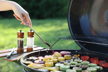 Vegetarian barbeque. Woman cooking vegetables on grill outdoors, closeup
