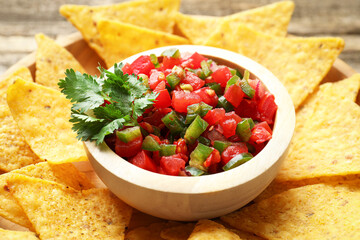 Tasty salsa with nachos on table, closeup
