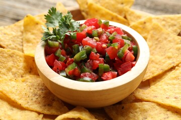 Tasty salsa with nachos on table, closeup