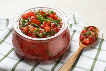 Tasty salsa in jar on white table, closeup