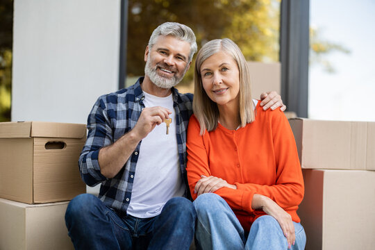 Senior couple smiling while man holding keys celebrating new home purchase