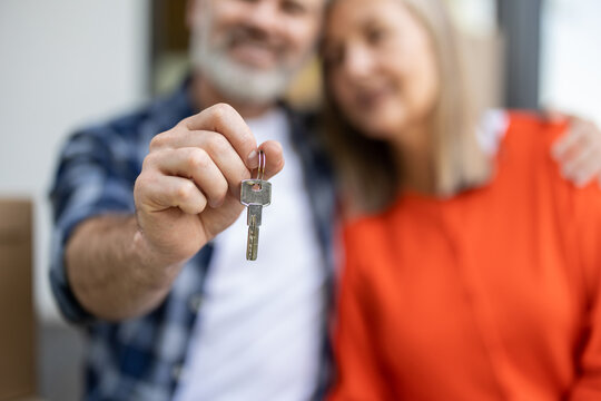 Closeup of keys of home in senior couple hands at entrance