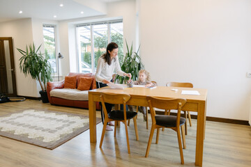 Woman and a kid drawing indoors