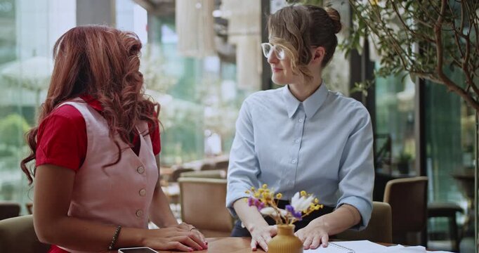 Two multicultural startup business people engage in a productive meeting, collaborating on project ideas. They finalize their discussion with a firm handshake, symbolizing successful partnership.