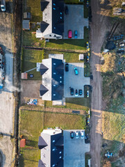 Nowoczesny dom na osiedlu z widokiem na błękitne niebo. Jasna elewacja, duże okna i prosta forma podkreślają współczesny styl architektury. Ujęcie oddaje harmonię między nowoczesnym budownictwem a spo © Freshfanpage