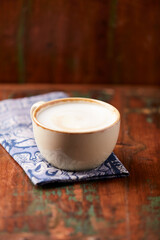 Cappuccino on dark wooden background. Soft focus. Close up