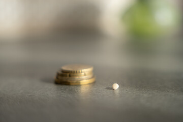 Close-up of a baby tooth lying in front of a stack of coins. Concept of tooth fairy tradition, childhood milestones and symbolic rewards.