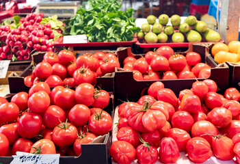 A farm stand with various types of autumn tomatoes, radishes, zucchini and lettuce at the central market in Riga, Latvia.