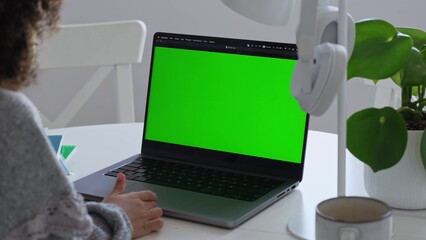 Primary school Student African American child with headphones using laptop green screen chroma key. Distance learning online education. Schoolboy girl studying at home with digital tablet computer and
