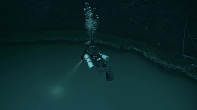 An ethereal image capturing a scuba diver descending toward the infamous hydrogen sulfide cloud layer of Cenote Angelita in the Yucat&aacute;n.