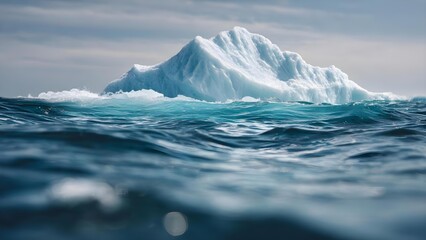 Fototapeta premium A large iceberg floating in the ocean, with jagged blue ice rising above the dark, choppy sea. Concept Arctic landscape, Iceberg photography, Jagged blue ice, Dark choppy sea, Dramatic seascape