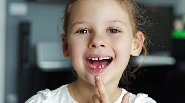 Close-up portrait of child smiling with missing baby tooth and pointing finger. A proud moment of growing up and celebrating childhood milestones.