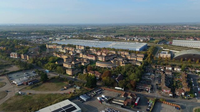 Aerial drone view of industrial warehouses and factories near residential property at sunset in Purfleet on Thames, UK