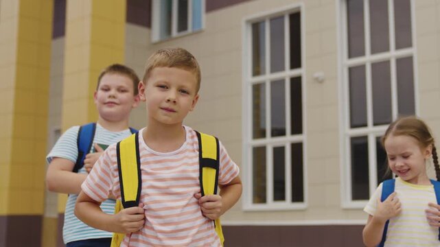 Group of cheerful pupils at school entrance, Young classmates meeting outside, Kids enjoying first day of school, Friends going to class, School building and students, School children holding