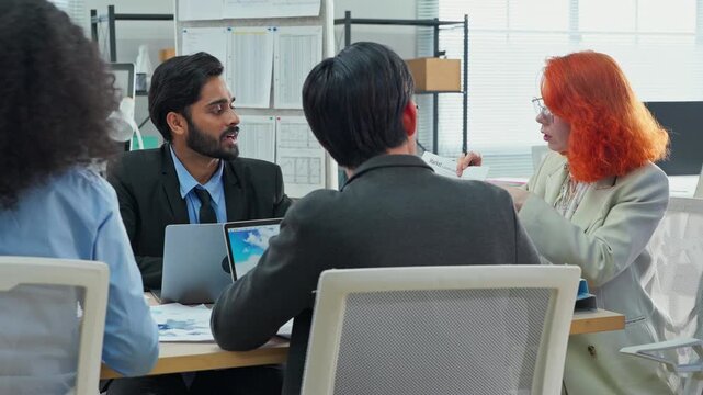 Multiethnic business professionals collaborate in modern office using AI virtual assistant and big data analytics to connect insights, driving strategic innovation through intelligent automation