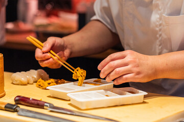 Sushi chef preparing fresh ingredients with precision and skillful technique