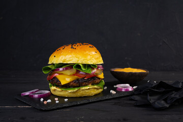 Juicy grilled burger with melted cheese, sauce and fresh toppings