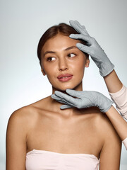 Doctor in gloves touching woman face with gentle care and patient confidence during consultation....