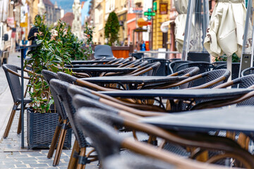Outdoor cafe with empty wooden tables and chairs on the patio. Inviting relaxation and leisurely moments.