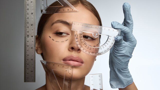 Woman face framed by transparent rulers symbolizing measurement and beauty standards. Concept of body image, perfection pressure, social critique, and conceptual art reflection.