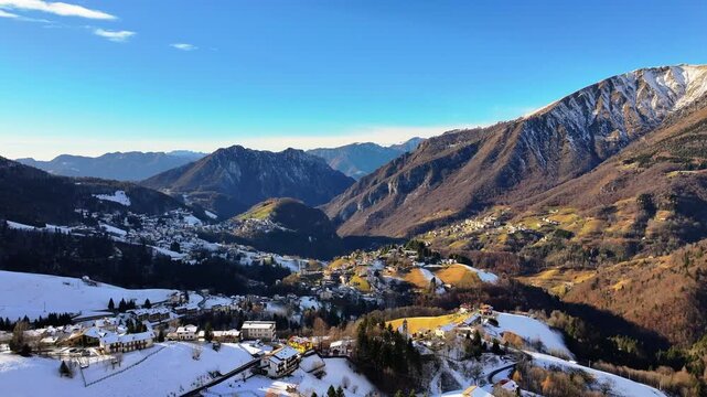 Aerial view of Zambla town and background Orobie alps with snow, Bergamo, Italy