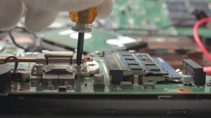 Close up technician hand repairing computer motherboard with screwdriver, Detailed view of electronic component maintenance process with precision tool in workshop