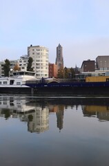 Skyline of Arnhem in the Netherlands. With the Eusebius church and a cargo ship on the river Rhine. Also a beautiful reflection in the water.