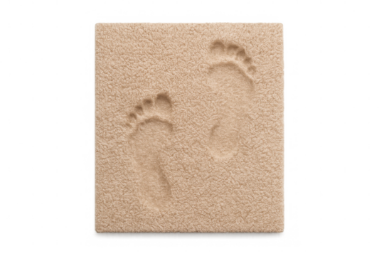 Bare footprints impressing into soft beige memory foam cushion, showing comfort and relaxation