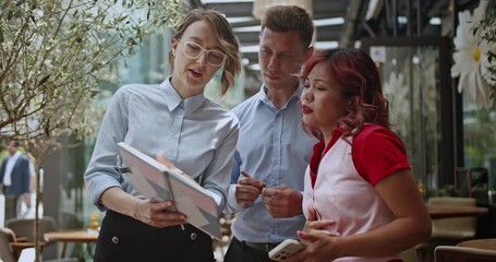 Business people collaborate and discuss ideas in a modern, dynamic workspace. Their smiling faces show teamwork and productive communication. Perfect for diverse teams and startup concepts. - Powered by Adobe