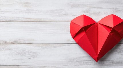 Crafted with love, a vibrant red paper heart-shaped origami rests on a rustic wooden background, perfect for romantic occasions and heartfelt gifts