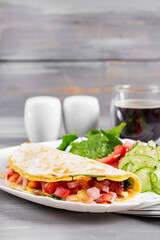 Healthy breakfast. Quesadilla with omelet, ham, cheese, and tomatoes.