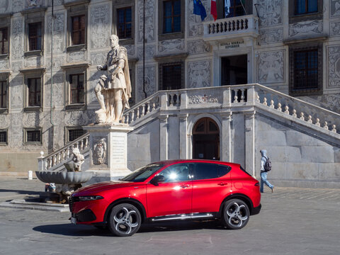 Red compact SUV parking in Piazza dei Cavalieri, Pisa, blending modern design with renaissance architecture and history