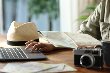 Tourist planning vacation checking maps and laptop