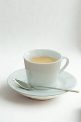 A cup of tea with a spoon on a saucer