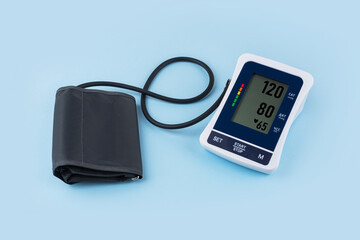 Digital Blood Pressure Monitor to measure blood pressure and heart rate isolated on blue background.