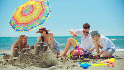 Happy family, including parents and children, enjoying a sunny day at the beach, collaborating on...