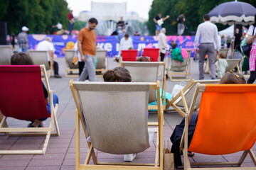 Enjoying a sunny day at an outdoor festival with colorful chairs and live performances