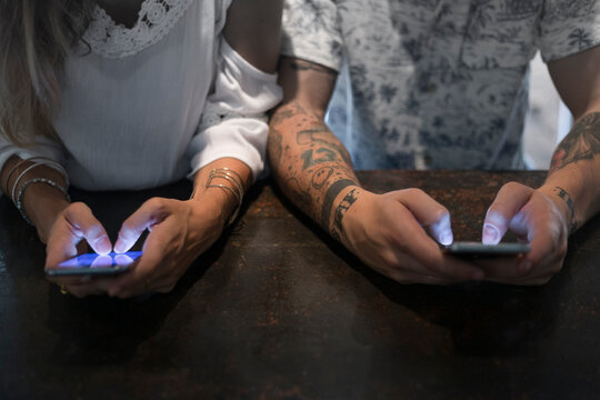 Close-up of couple using smartphones