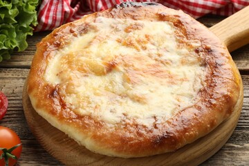 Delicious Megrelian khachapuri and products on wooden table, closeup
