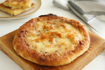 Delicious Megrelian khachapuri on white wooden table, closeup