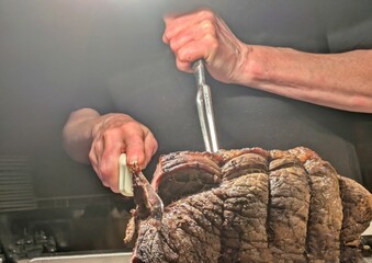 Hands carving roast beef