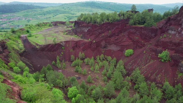 Red volcanic crater of Racos in Brasov, Romania, now covered with lush green vegetation