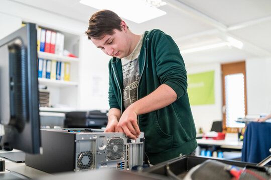 Teenager assembling personal computer